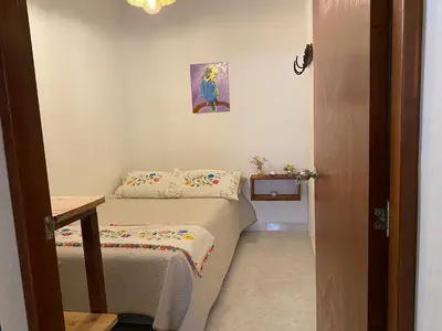 a small room with two beds and a table at Acogedor apartaestudio cerca al parque principal in Jardin