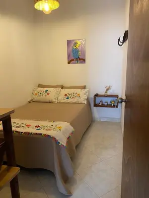 a bedroom with a bed with a blanket on it at Acogedor apartaestudio cerca al parque principal in Jardin