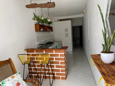 a kitchen with a brick counter and yellow chairs at Acogedor apartaestudio cerca al parque principal in Jardin