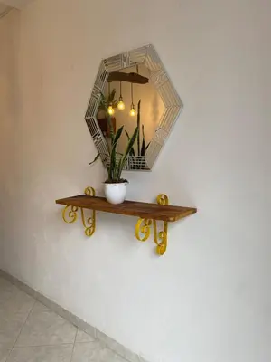 a mirror on a wall with a potted plant on a shelf at Acogedor apartaestudio cerca al parque principal in Jardin