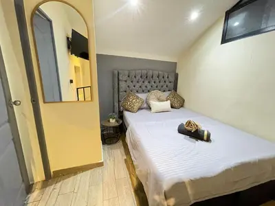 a small bedroom with a bed and a mirror at la huerta in Medellín
