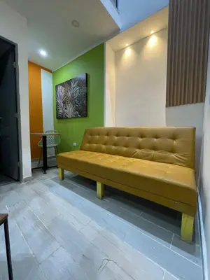 a brown couch in a room with green walls at la huerta de 1 alcoba in Medellín