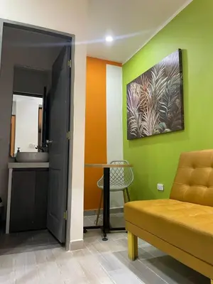 a room with a bed and a table and a sink at la huerta de 1 alcoba in Medellín