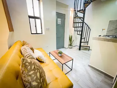 a living room with a yellow couch and a table at la huerta de 1 alcoba in Medellín