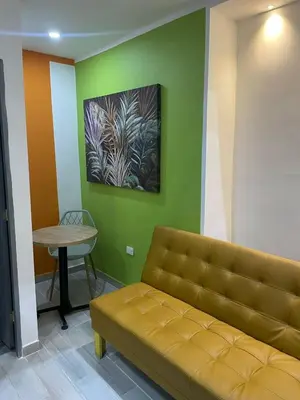 a couch in a room with a table and a painting at la huerta de 1 alcoba in Medellín