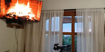 a fireplace in a room next to a window at Cabaña Sensorial Vista y Silencio Total a 40 minutos de Medellín in San Vicente
