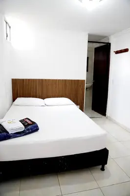 a white bed in a room with at Hotel Brisas del Atanasio in Medellín