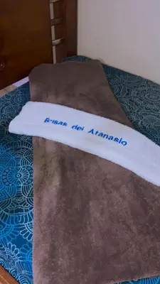 a towel that says please not a blanket on a bed at Hotel Brisas del Atanasio in Medellín