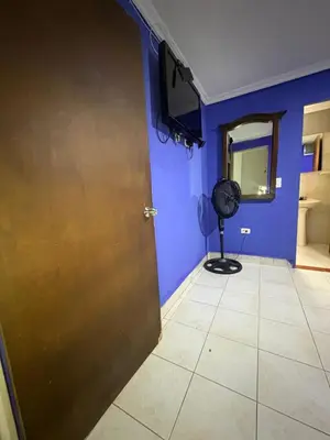a room with blue walls and a door with a fan at Hotel Brisas del Atanasio in Medellín