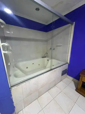 a bathroom with a tub with a glass wall at Hotel Brisas del Atanasio in Medellín