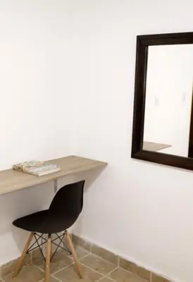 a desk with a chair and a mirror at Hotel Brisas del Atanasio in Medellín