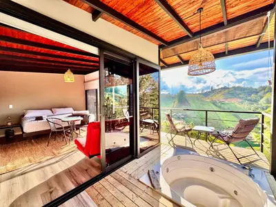 a bathroom with a tub and a bedroom with a view at Agua Santa Ecolodge in Guatapé