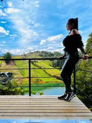 a woman standing on a bridge looking at a river at Agua Santa Ecolodge in Guatapé