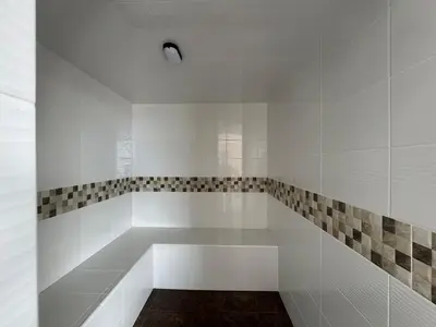 a white bathroom with a bench in the corner at Aluna in Estación El Salto