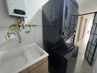 a kitchen with a sink and a black refrigerator at Aluna in Estación El Salto