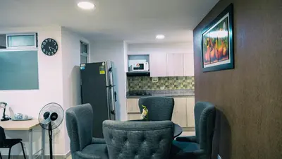 a kitchen with chairs and a table and a refrigerator at 801-Acogedor Apto 2BR Parque Sabaneta in Sabaneta