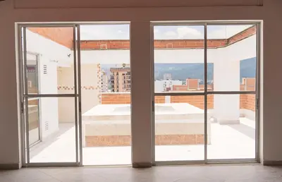 an open glass door with a view of a building at 504-Apartamento 3BR a Pasos del Parque de Sabaneta in Sabaneta