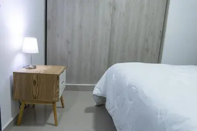 a bedroom with a bed and a nightstand with a lamp at 1101- Cozy 2BR Apartment near Sabaneta Park in Sabaneta