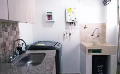 a small kitchen with a sink and a washing machine at 1101- Cozy 2BR Apartment near Sabaneta Park in Sabaneta
