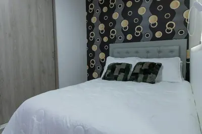 a white bed with two pillows in a bedroom at 1101- Cozy 2BR Apartment near Sabaneta Park in Sabaneta