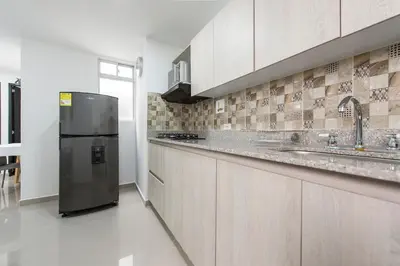 a large kitchen with a stainless steel refrigerator at 1101- Cozy 2BR Apartment near Sabaneta Park in Sabaneta