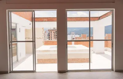 an empty room with two sliding glass doors at 1101- Cozy 2BR Apartment near Sabaneta Park in Sabaneta