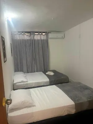 two beds in a small room with a window at Absolute Nova Hotel in Medellín
