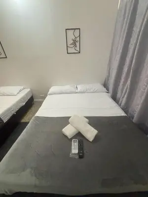 a bedroom with two beds and a remote control at Absolute Nova Hotel in Medellín