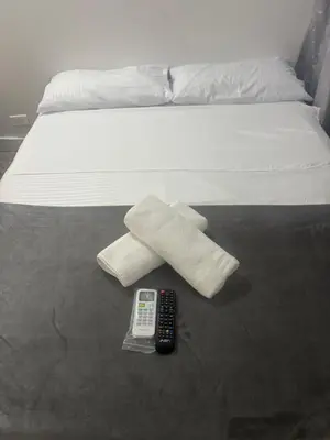 a white bed with a remote control and a remote control at Absolute Nova Hotel in Medellín