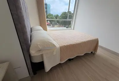 a bed in a room with a large window at Acogedor y Moderno - Estrato 6 in Manizales