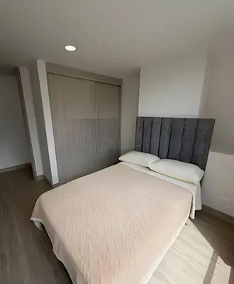 a bedroom with a large bed with white sheets at Acogedor y Moderno - Estrato 6 in Manizales