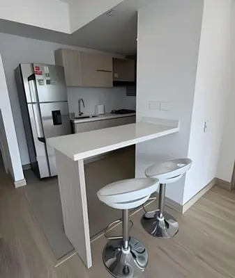 a white kitchen with a counter and two stools at Acogedor y Moderno - Estrato 6 in Manizales