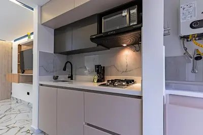 a kitchen with a stove and a microwave at Exclusivo Urban Loft en Laureles in Medellín