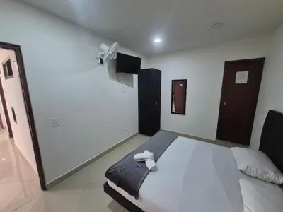 a bedroom with a large bed with a white at hotel universo plaza in Medellín