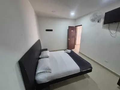 a bedroom with a bed in a white room at hotel universo plaza in Medellín