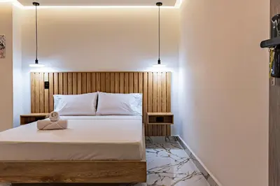a bedroom with a bed and two pendant lights at apartaloft laureles 70 in Medellín