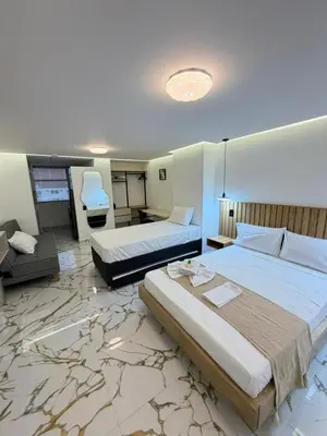 a hotel room with two beds and a desk at apartaloft laureles 70 in Medellín