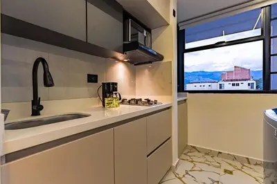 a kitchen with a sink and a window at apartaloft laureles 70 in Medellín