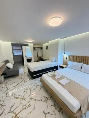 a hotel room with two beds and a desk at apartaloft laureles 70 in Medellín