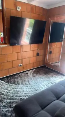 a room with a brick wall with a mirror and a couch at Camino de los Vientos in Bello