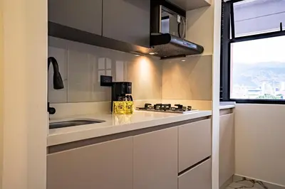 a kitchen with white cabinets and a sink and a window at prime loft 72 laureles in Medellín