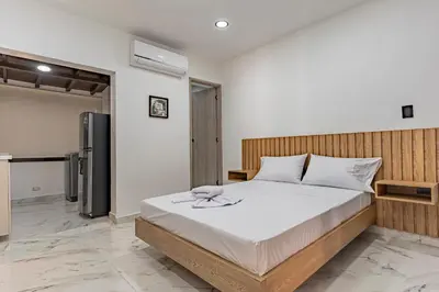 a bedroom with a large bed and a refrigerator at Fountain Loft 72 in Medellín