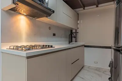 a kitchen with white cabinets and a stove top oven at Fountain Loft 72 in Medellín