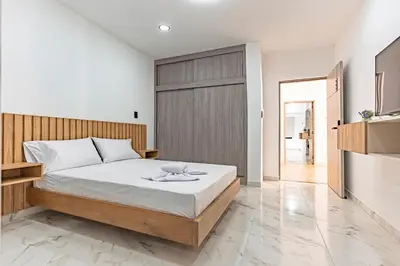 a bedroom with a large bed with white sheets at Fountain Loft 72 in Medellín