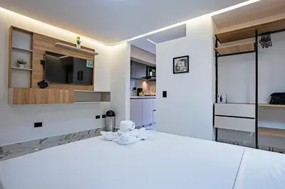 a white room with a large bed and a television at Apartaloft exclusivo en laureles in Medellín