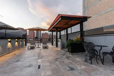 a patio with tables and chairs on a building at Apartaloft exclusivo en laureles in Medellín