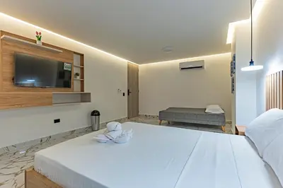 a bedroom with a large white bed with a flat screen tv at Exclusivo Urban Loft en Laureles in Medellín