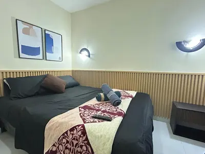 a bedroom with a bed with two remotes on it at la pausa 3 Los molinos in Medellín