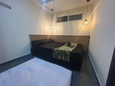 a small bed in a small room with two lights at la pausa 3 Los molinos in Medellín