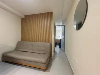 a couch in a room with a mirror at la pausa 3 Los molinos in Medellín